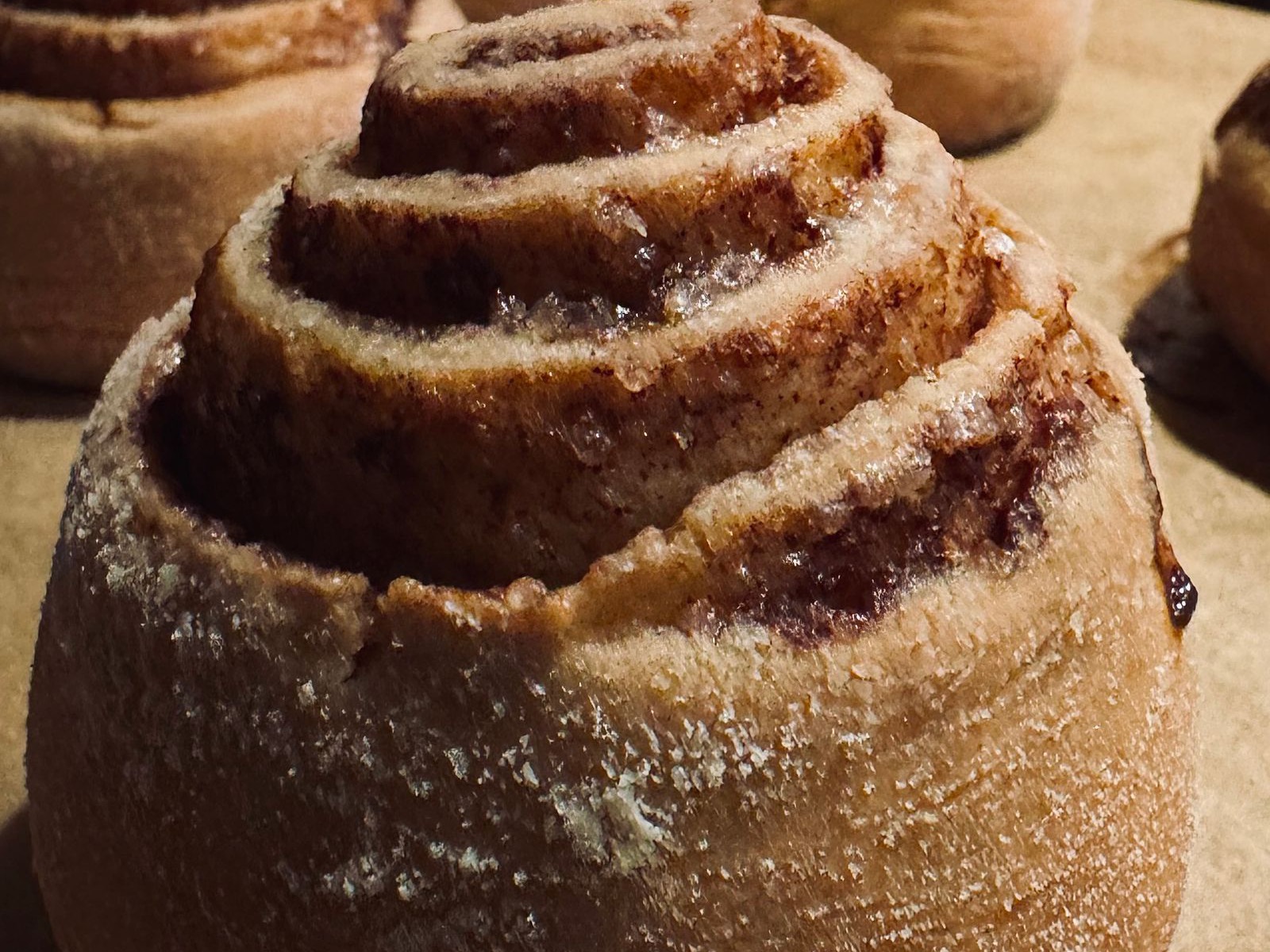 A sugar-crusted morning bun with a cinnamon swirl through it