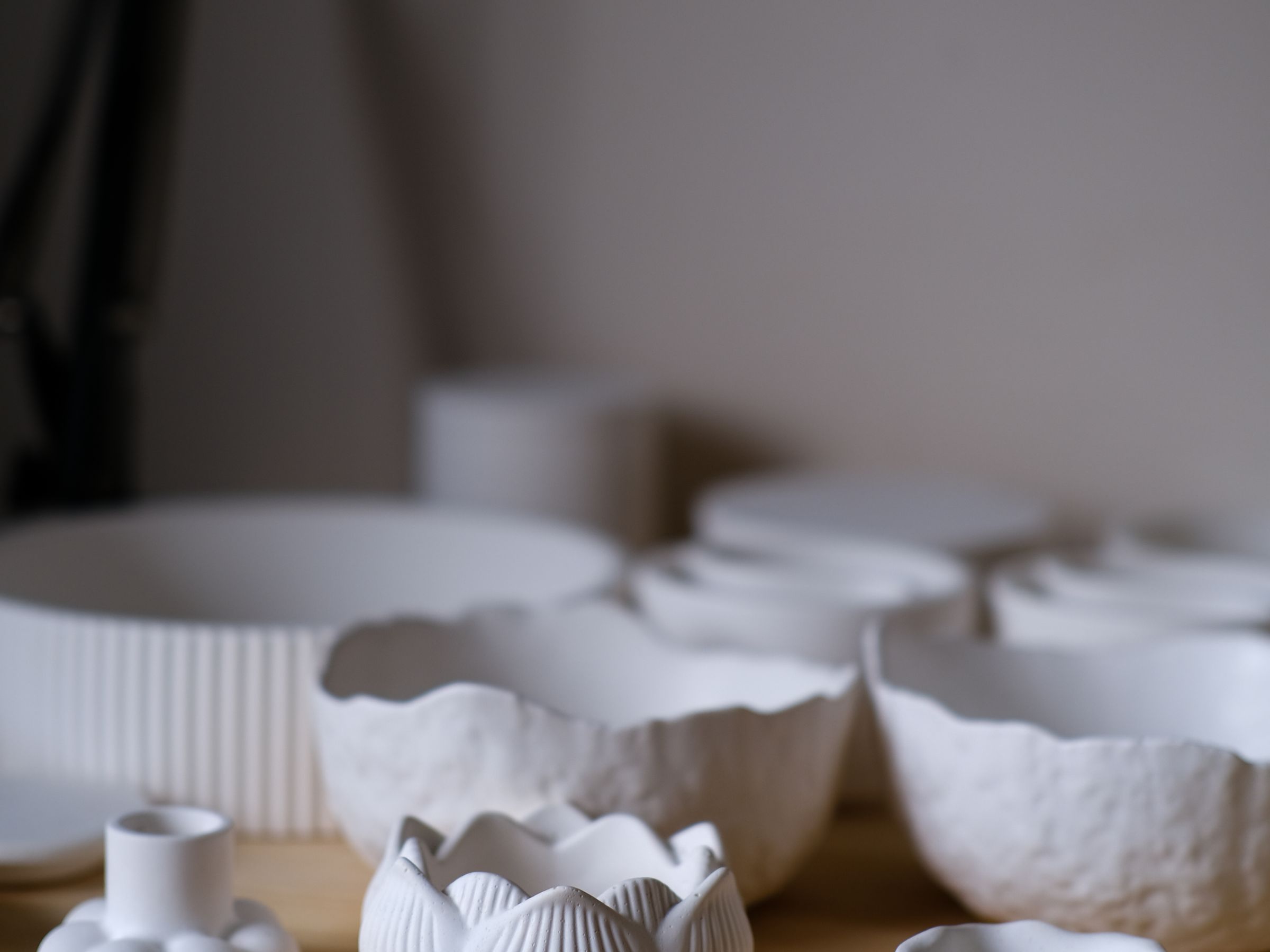 A pair of white artisan ceramic bowls on a wooden table